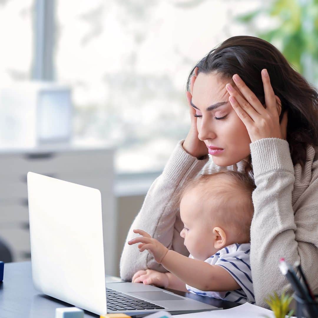 Mutter sitzt am Laptop und schreibt eine Bewerbung